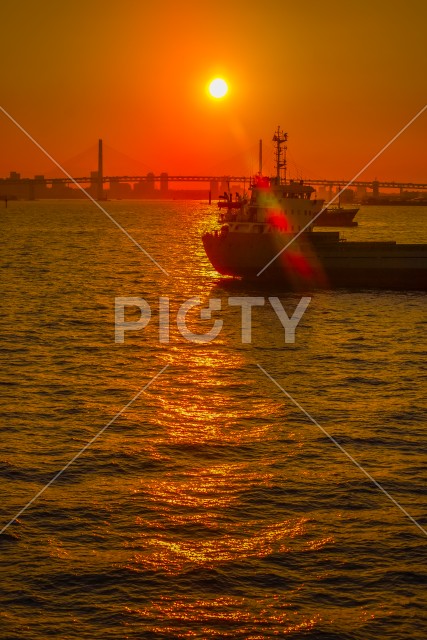 貨物船のシルエットと横浜の街並みの夕景