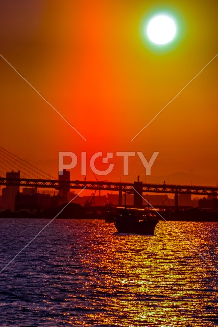 貨物船のシルエットと夕景