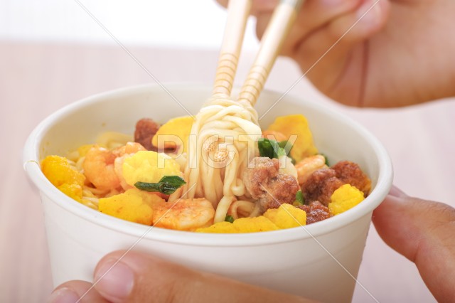 カップラーメンを食べる若い女性