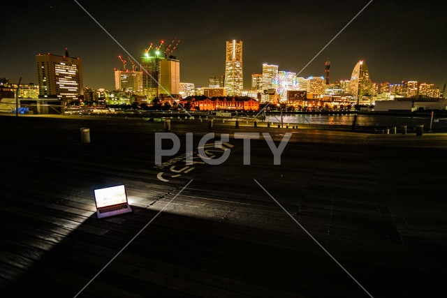 横浜の夜景とノートパソコン（ノマドワーカーのイメージ）