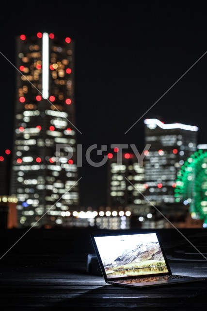 横浜の夜景とノートパソコン（ノマドワーカーのイメージ）