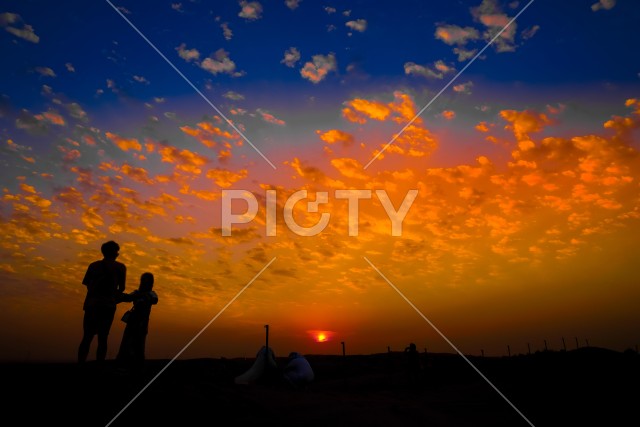 アラビア砂漠の夕暮れと人々のシルエット