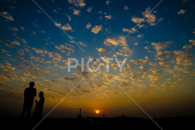 アラビア砂漠の夕暮れと人々のシルエット