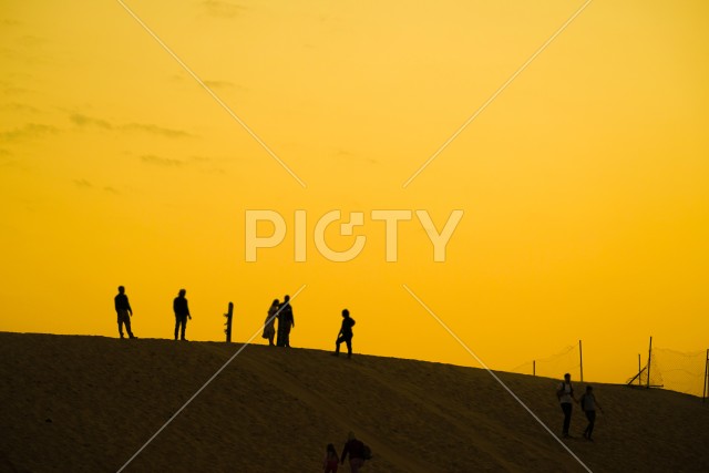 アラビア砂漠の夕暮れと人々のシルエット