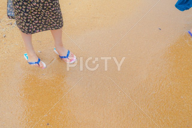 砂浜を歩く女性の足