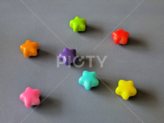 グレーの背景に散りばめられたカラフルな星型のラムネ菓子