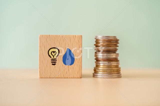 電気とガスのマークが書かれた積み木とお金